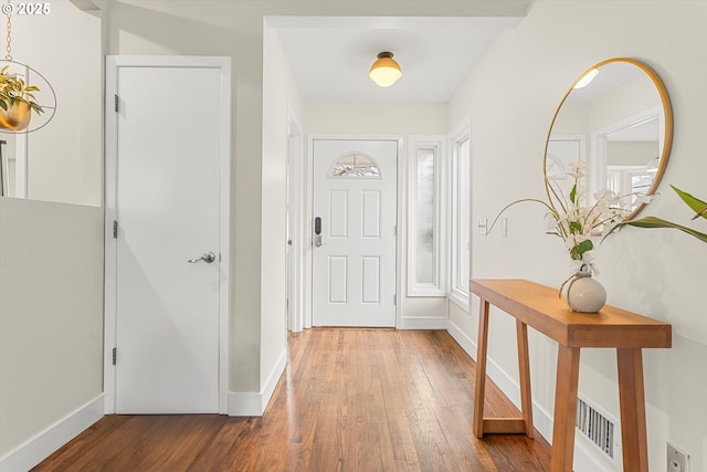 foyer featuring hardwood / wood-style floors and baseboards