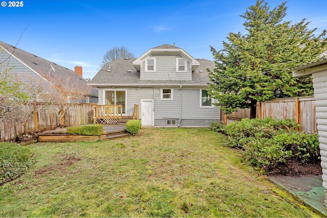 back of house featuring a fenced backyard, a lawn, a deck, and roof with shingles