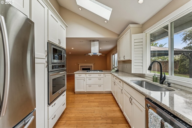 1722 Sequoia Ct, Forest Grove, OR 97116 - kitchen featuring appliances with stainless steel finishes, range hood, plenty of natural light, vaulted ceiling, and a skylight