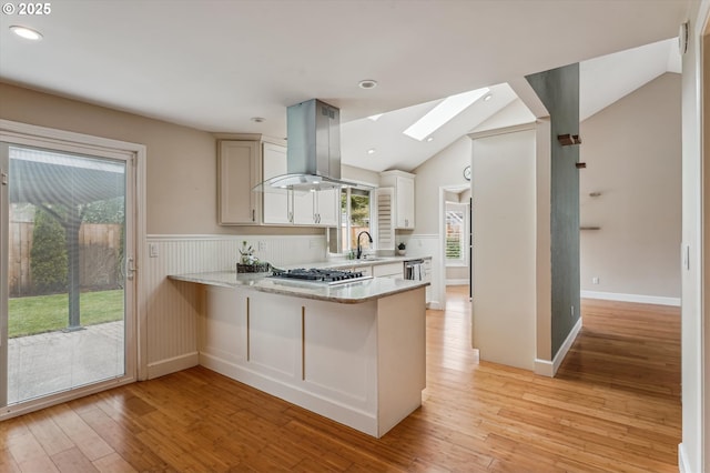 1722 Sequoia Ct, Forest Grove, OR 97116 - kitchen with island range hood, a skylight, light wood-style floors, lofted ceiling, and a peninsula