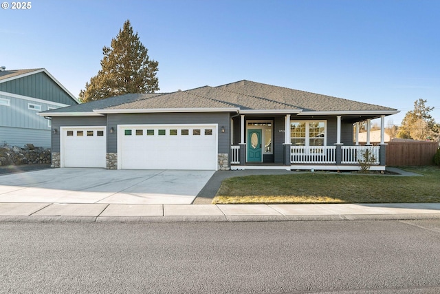 view of front of house featuring a garage, a front yard, and covered porch