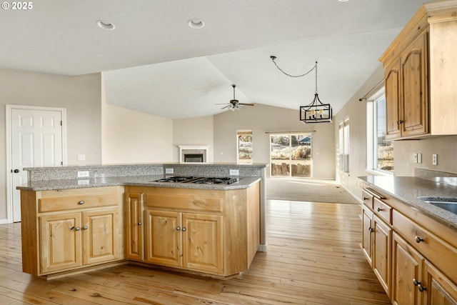 kitchen with light hardwood / wood-style flooring, ceiling fan with notable chandelier, plenty of natural light, and stainless steel gas cooktop