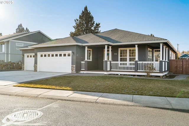 view of front of home featuring a porch, a garage, and a front yard