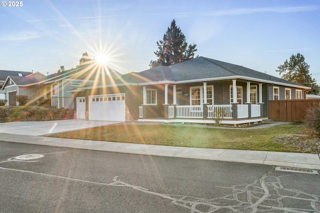 view of front facade featuring a garage, a front lawn, and a porch