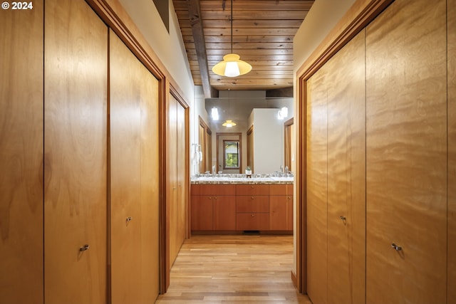 corridor with light wood-style flooring and wood ceiling