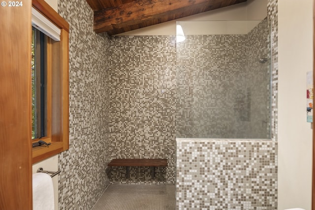 bathroom with tiled shower and beam ceiling