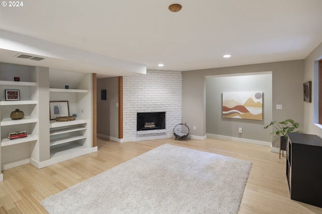 living area with a fireplace, light wood-style flooring, recessed lighting, baseboards, and visible vents