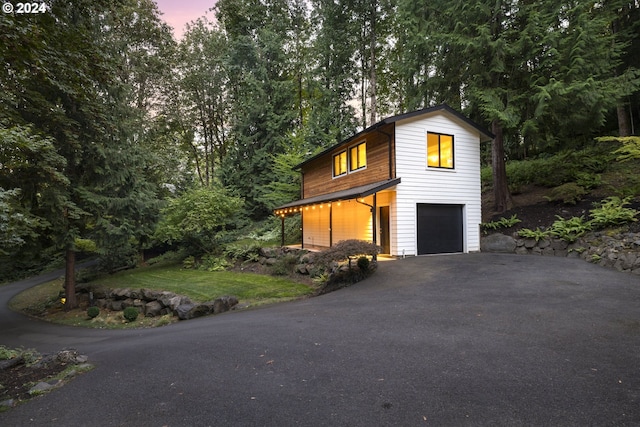 property exterior at dusk with an attached garage and driveway
