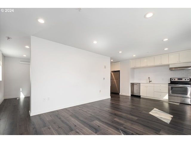 kitchen with appliances with stainless steel finishes, a sink, white cabinetry, dark wood-type flooring, and under cabinet range hood