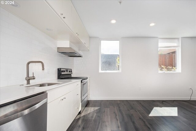 1480 N Jarrett St Unit 103, Portland, OR 97217 - kitchen with white cabinets, dark wood-style flooring, a sink, plenty of natural light, and stainless steel appliances