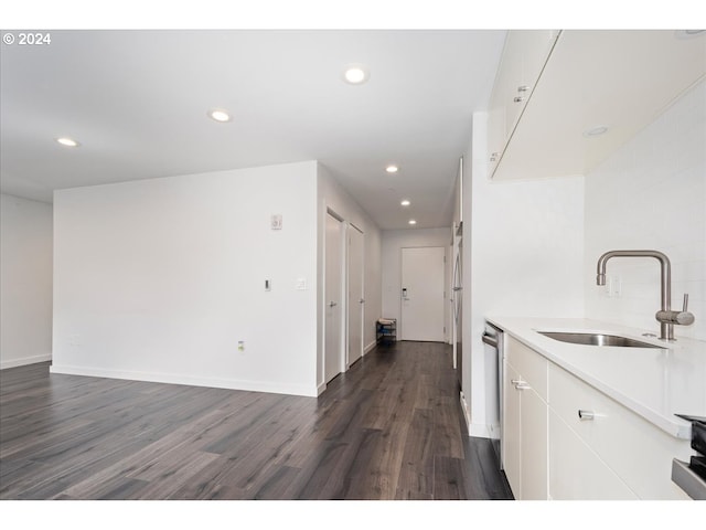 kitchen with dark wood-style flooring, recessed lighting, white cabinetry, and a sink