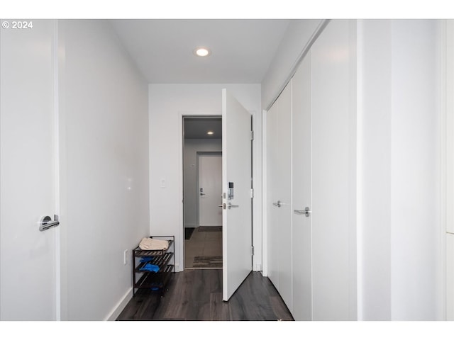 hallway with dark wood-style flooring, baseboards, and recessed lighting