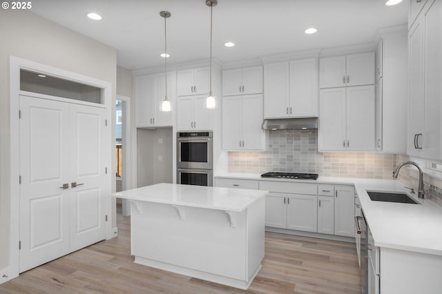 kitchen with white cabinetry, double oven, pendant lighting, and a center island