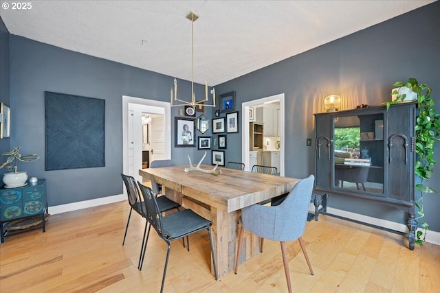 dining area with light wood-style floors and baseboards