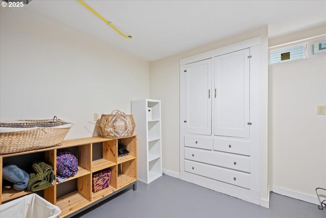 recreation room with finished concrete floors and baseboards