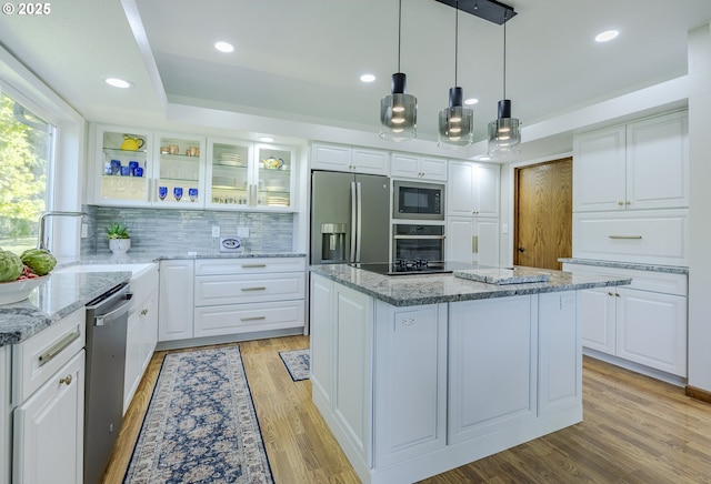 38201 Queens Rd, Marcola, OR 97454 - kitchen with decorative backsplash, glass insert cabinets, a center island, a sink, and appliances with stainless steel finishes