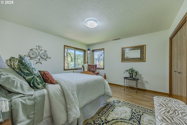 38201 Queens Rd, Marcola, OR 97454 - bedroom featuring visible vents, a textured ceiling, light wood-style floors, and baseboards