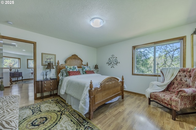 38201 Queens Rd, Marcola, OR 97454 - bedroom with baseboards, multiple windows, a textured ceiling, and light wood-style flooring