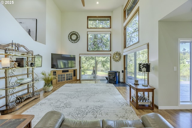 38201 Queens Rd, Marcola, OR 97454 - living area with baseboards, a wood stove, wood finished floors, and a towering ceiling