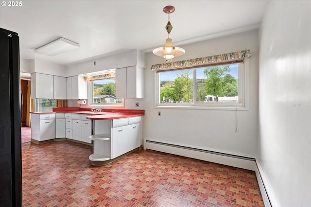 901 H Ave, La Grande, OR 97850 - kitchen featuring white cabinets, hanging light fixtures, brick patterned flooring, a sink, and baseboards