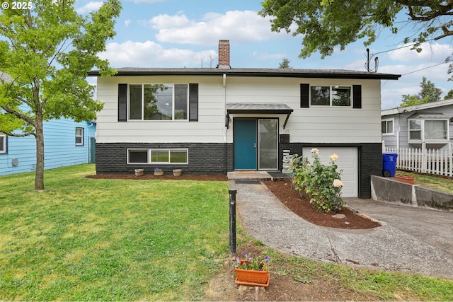 split foyer home featuring a garage and a front lawn