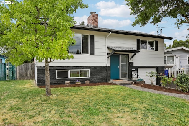 split foyer home featuring a garage and a front yard