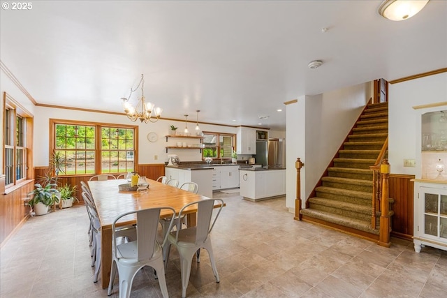 26127 NW Williams Canyon Rd, Gaston, OR 97119 - dining area with wainscoting, a chandelier, stairway, wooden walls, and ornamental molding