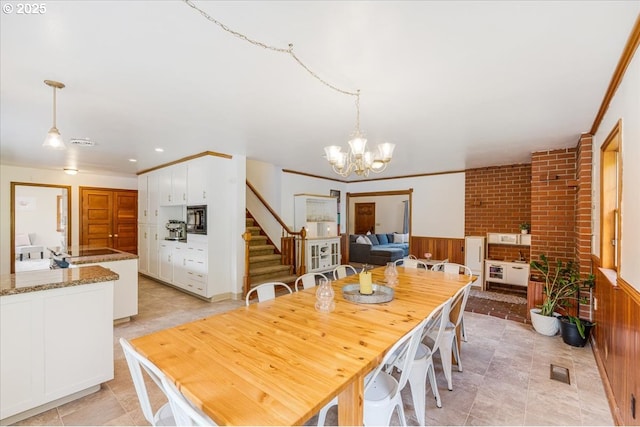 26127 NW Williams Canyon Rd, Gaston, OR 97119 - dining space featuring stairway, a chandelier, wainscoting, and brick wall