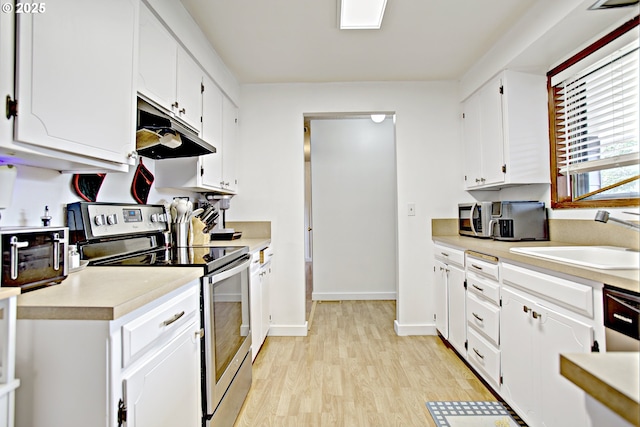21408 SE Main St, Gresham, OR 97030 - kitchen featuring stainless steel electric range, under cabinet range hood, light countertops, a sink, and light wood-style flooring
