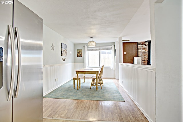 21408 SE Main St, Gresham, OR 97030 - dining room with wood finished floors, a wainscoted wall, a textured ceiling, and baseboards