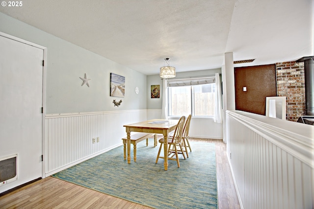 21408 SE Main St, Gresham, OR 97030 - dining room with wood finished floors, a wood stove, wainscoting, and heating unit