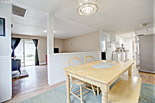 21408 SE Main St, Gresham, OR 97030 - dining room with light wood-style flooring, wainscoting, and a chandelier