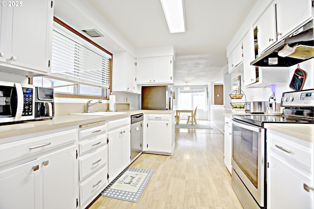 21408 SE Main St, Gresham, OR 97030 - kitchen featuring stainless steel appliances, a sink, white cabinets, under cabinet range hood, and light wood finished floors