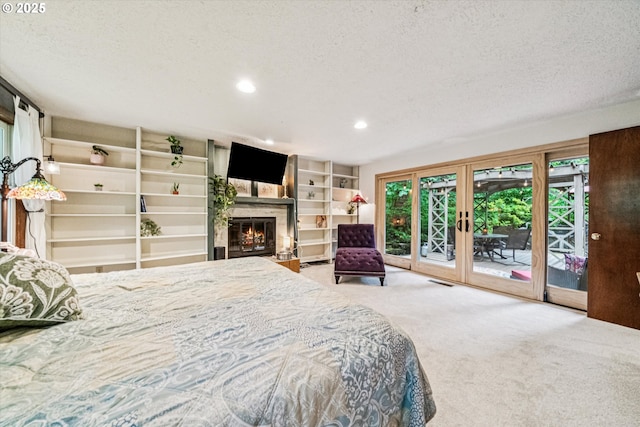 22060 S Forest Park Rd, Beavercreek, OR 97004 - carpeted bedroom with access to exterior, a textured ceiling, multiple windows, recessed lighting, and a glass covered fireplace