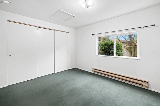 unfurnished bedroom with dark carpet, baseboard heating, and a closet