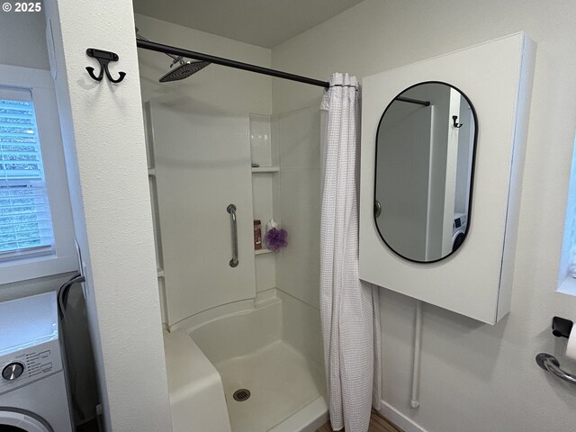 full bath featuring washer / dryer and a shower stall