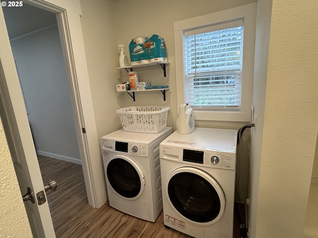 laundry room featuring laundry area, baseboards, separate washer and dryer, and wood finished floors