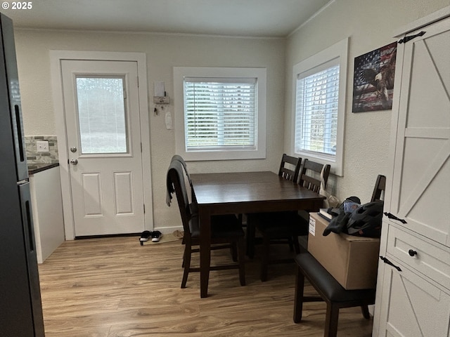 dining room with light wood-style floors and ornamental molding