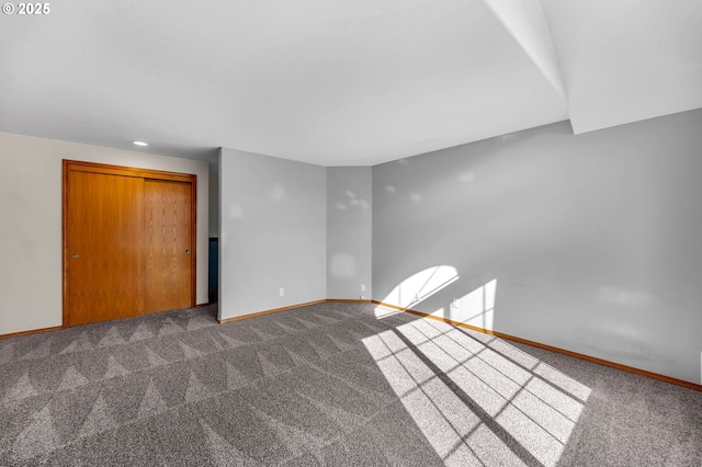 unfurnished room featuring carpet and baseboards