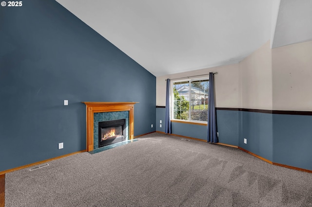 unfurnished living room featuring a fireplace with flush hearth, visible vents, vaulted ceiling, and carpet flooring