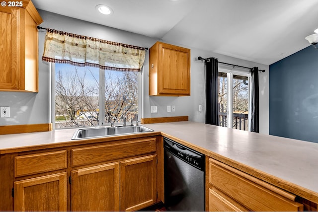 kitchen featuring light countertops, stainless steel dishwasher, a sink, and brown cabinets