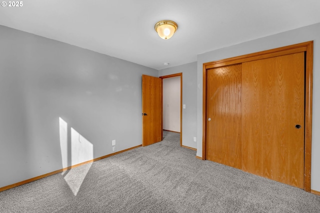 unfurnished bedroom featuring a closet, carpet flooring, and baseboards