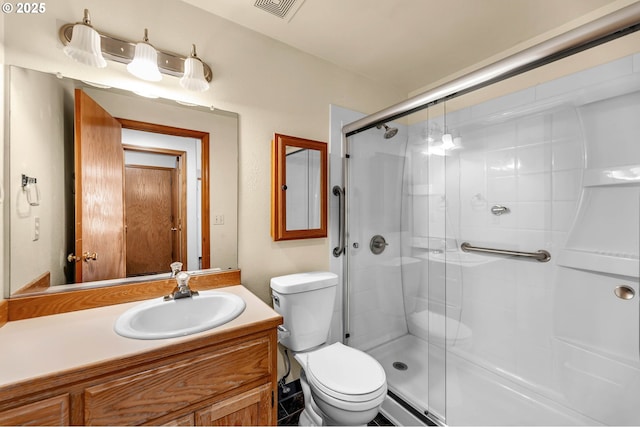 bathroom featuring toilet, vanity, a shower stall, and visible vents