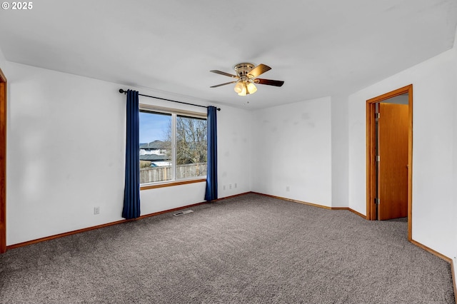 carpeted spare room featuring baseboards, visible vents, and a ceiling fan