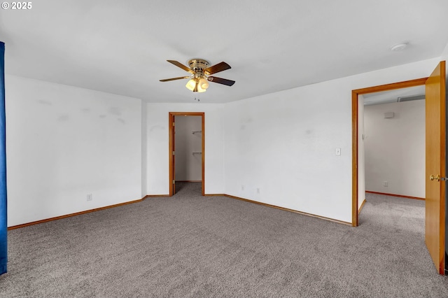 carpeted empty room with a ceiling fan, visible vents, and baseboards