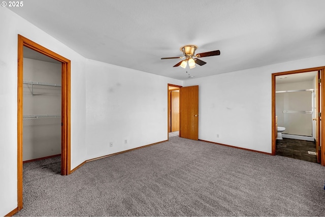 unfurnished bedroom with carpet floors, a spacious closet, a closet, and baseboards