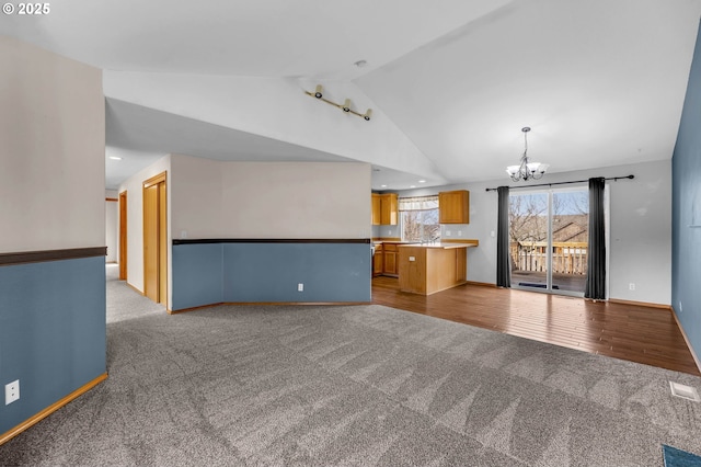 unfurnished living room featuring carpet, vaulted ceiling, visible vents, and a notable chandelier