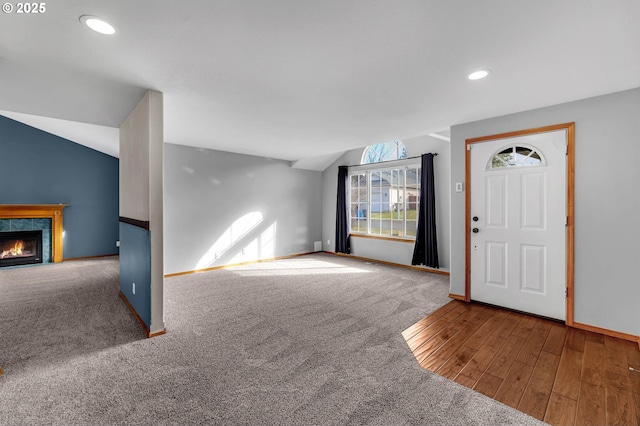 interior space with lofted ceiling, recessed lighting, a fireplace, carpet flooring, and baseboards