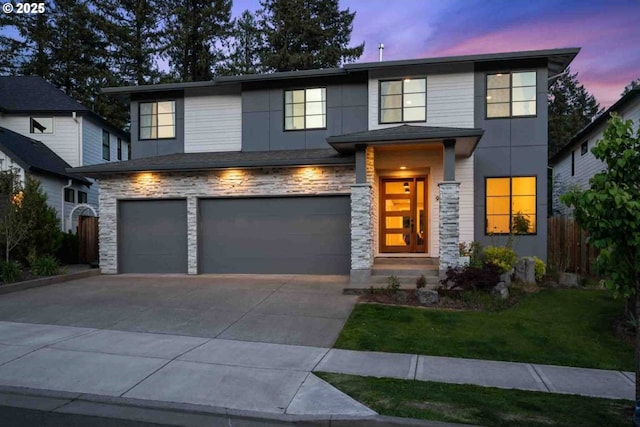 view of front facade featuring a garage, a front lawn, fence, stone siding, and concrete driveway