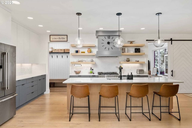 kitchen with a sink, modern cabinets, open shelves, and high quality fridge